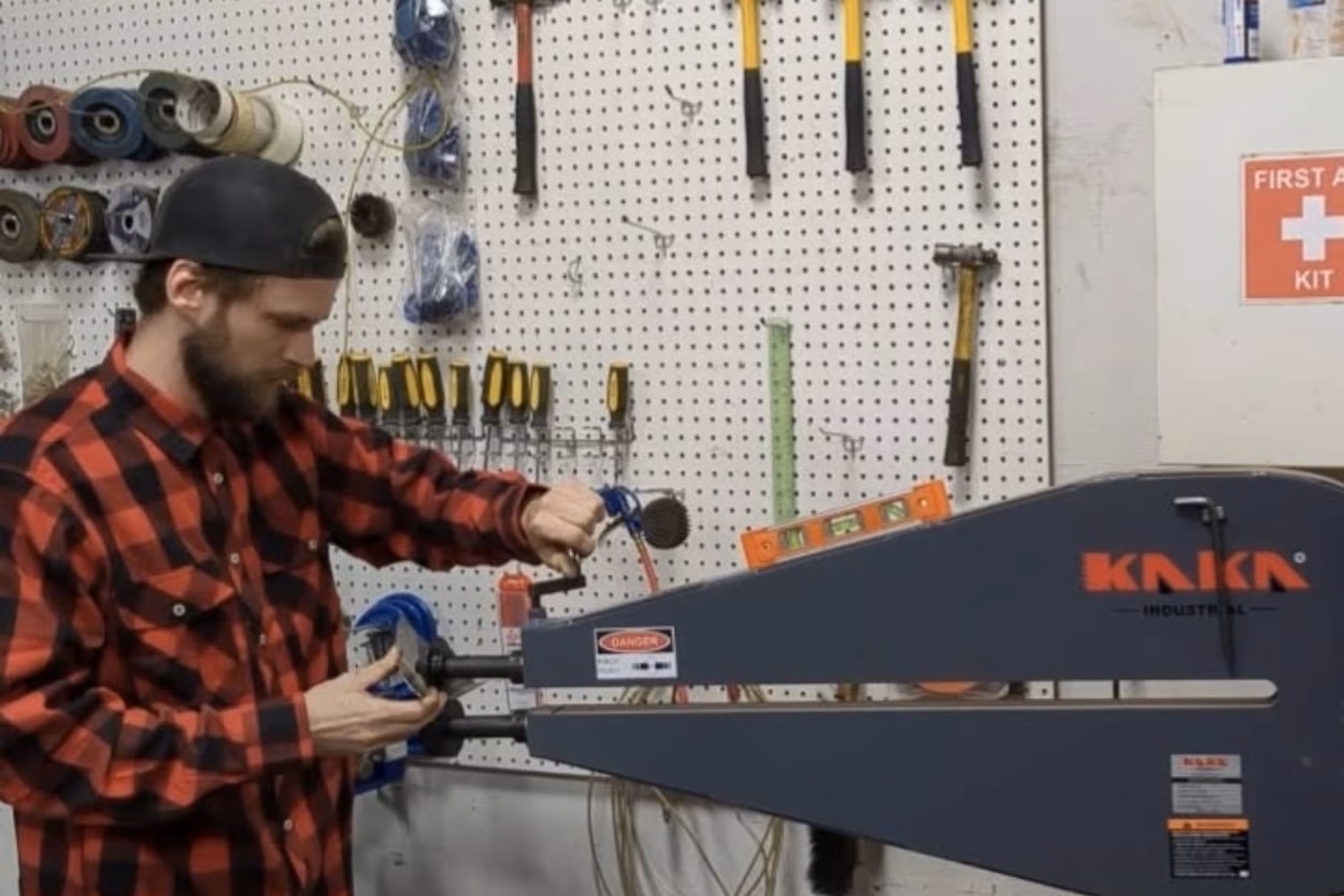 A fabricator using an industrial bead roller to add strength and detail to a sheet metal panel.